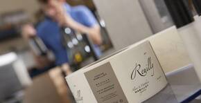 bouteille de Reuilly vide sur la table de dégustation, vigneron en arrière plan